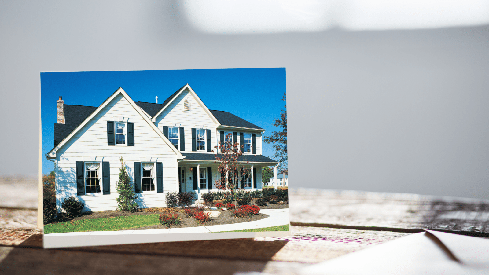 postcard with an image of a house sitting on a desk