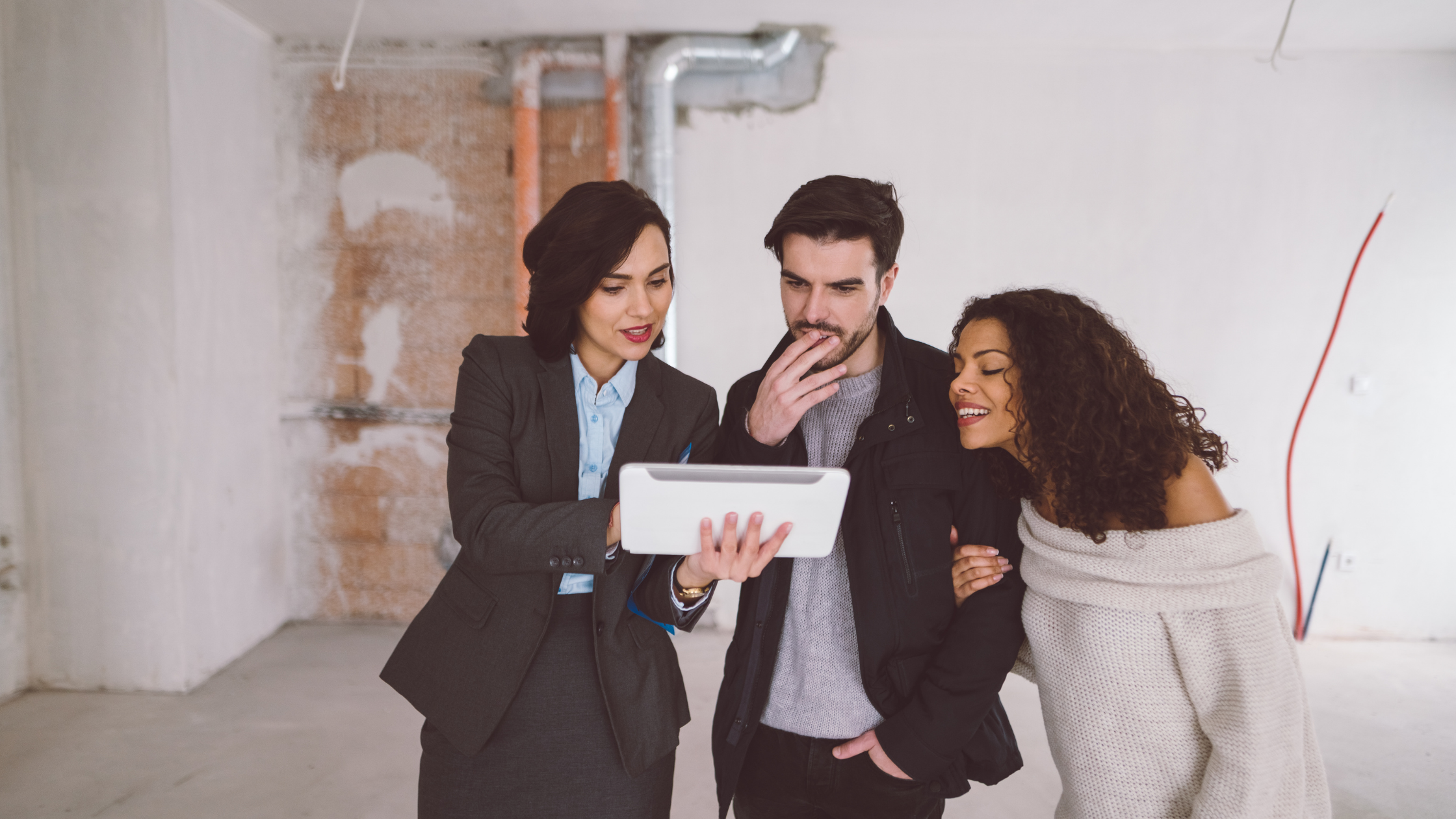three people gathered around a tablet discussing strategy